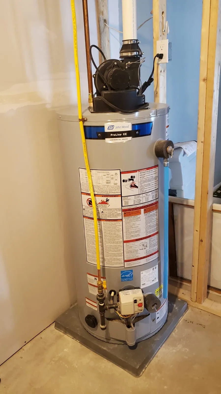John Wood ProLine XE gas hot water tank with its power-vent blower, installed by O'Grady Air in a basement