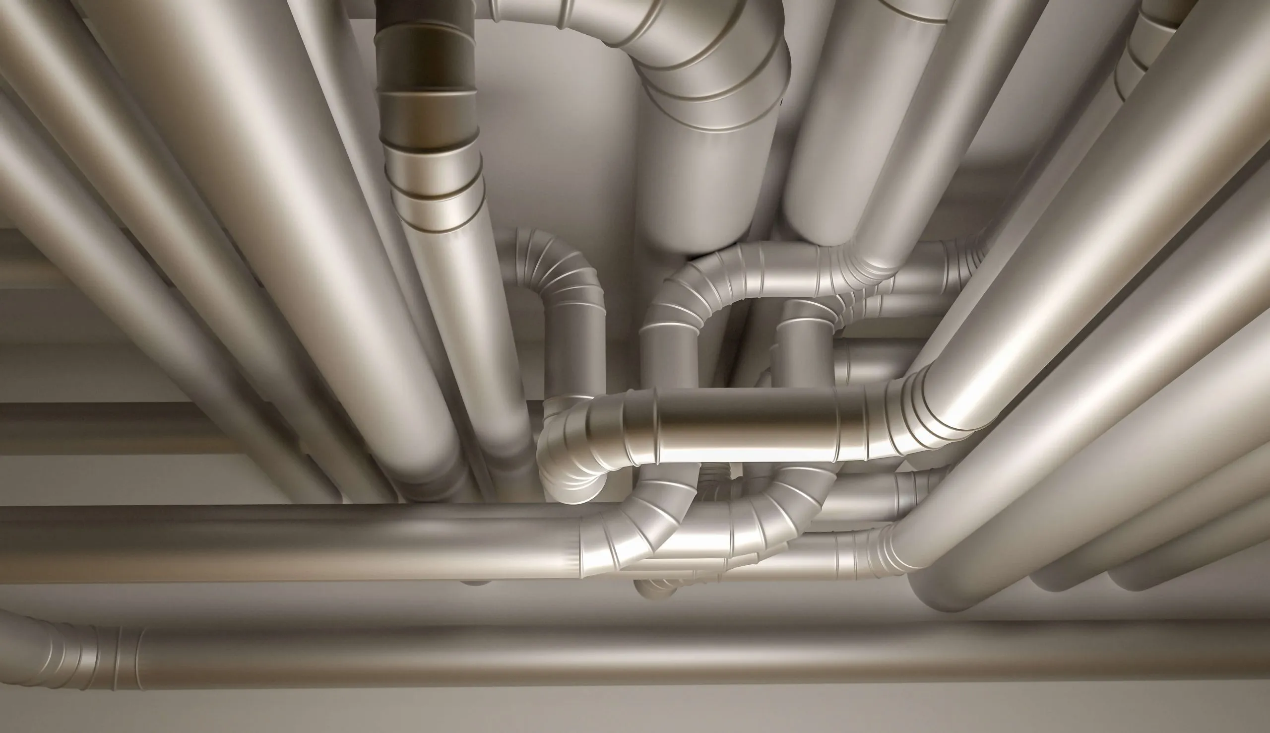 Round sheet-metal ducts and elbows running along a ceiling